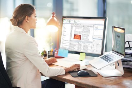 Woman sitting at her computer, using CommonLook PDF to remediate a PDF document for accessibility.